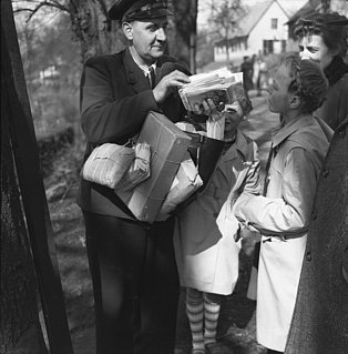 Postbote trägt die Post aus. Bild aus den 50er Jahren